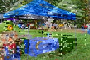 A scarecrow and a NOPEC branded tent image